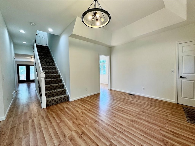 1502 6th Ave, Saint Joseph, MO 64505 - unfurnished living room with a healthy amount of sunlight, baseboards, stairs, and light wood-style flooring