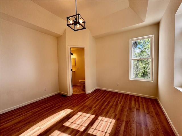 1502 6th Ave, Saint Joseph, MO 64505 - unfurnished bedroom with baseboards, ensuite bathroom, wood finished floors, and an inviting chandelier