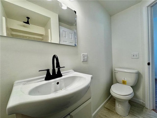 1502 6th Ave, Saint Joseph, MO 64505 - bathroom featuring toilet, baseboards, wood finished floors, and vanity