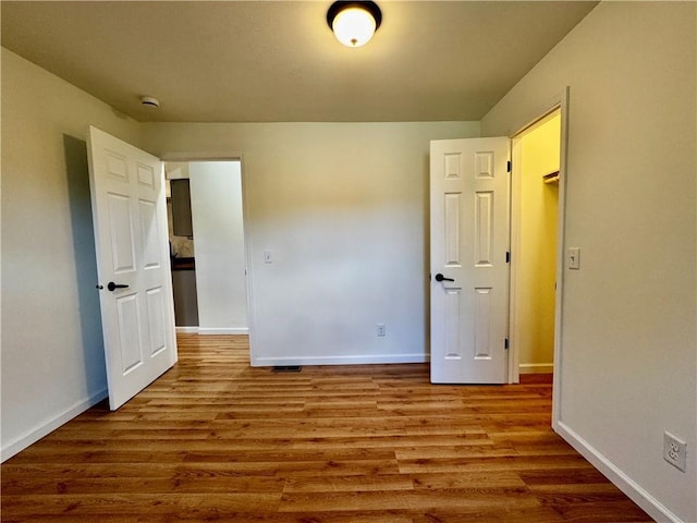 1502 6th Ave, Saint Joseph, MO 64505 - unfurnished bedroom with baseboards, wood finished floors, and visible vents