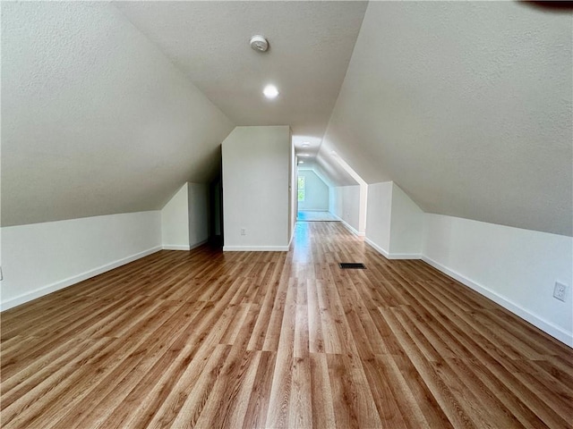 1502 6th Ave, Saint Joseph, MO 64505 - bonus room with a textured ceiling, visible vents, vaulted ceiling, wood finished floors, and baseboards