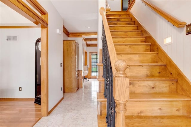 staircase featuring baseboards, visible vents, and marble finish floor
