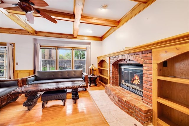living room featuring ceiling fan, a brick fireplace, light wood-type flooring, beamed ceiling, and coffered ceiling