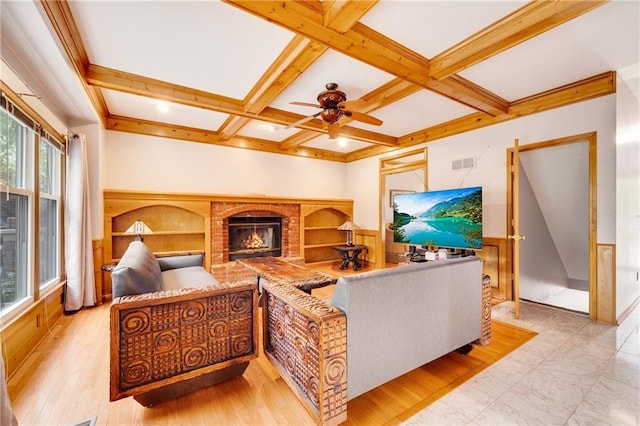 living room with ceiling fan, beam ceiling, a brick fireplace, visible vents, and coffered ceiling