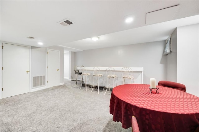 carpeted dining space featuring visible vents