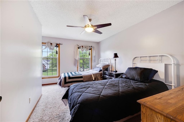 bedroom with carpet floors, a ceiling fan, a textured ceiling, and baseboards
