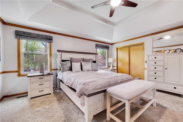 bedroom with light colored carpet, multiple windows, and a raised ceiling