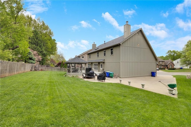 back of property featuring a patio, fence, a yard, and a chimney