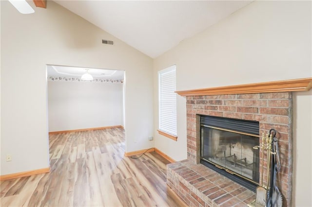 unfurnished living room featuring a brick fireplace, lofted ceiling, visible vents, baseboards, and wood finished floors