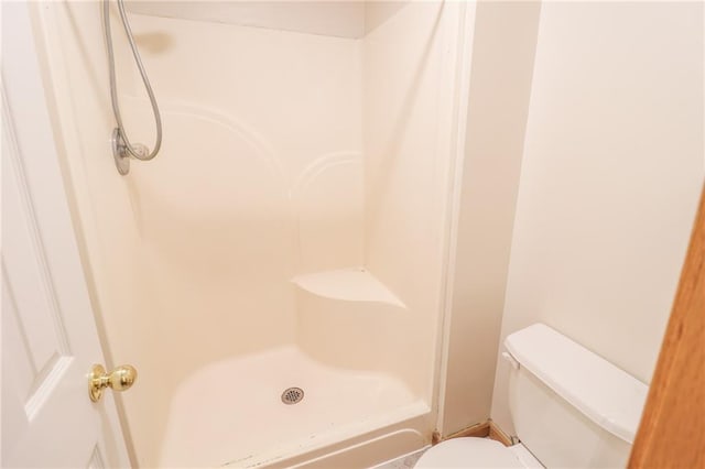 bathroom featuring walk in shower and toilet