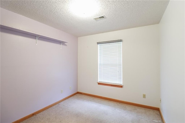 empty room with visible vents, light colored carpet, and baseboards