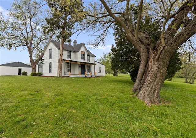 rear view of property with a lawn and a chimney
