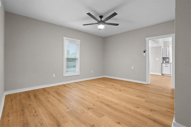 unfurnished room featuring light wood-style floors, baseboards, and ceiling fan