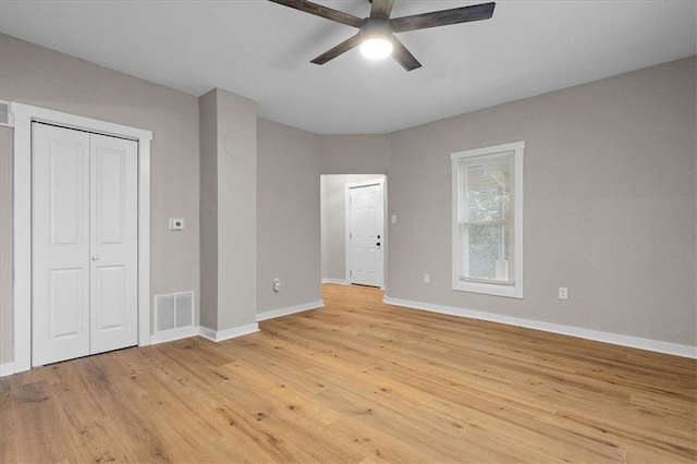 unfurnished bedroom with visible vents, a closet, baseboards, ceiling fan, and light wood-type flooring