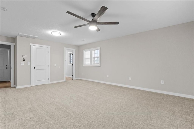 spare room featuring visible vents, baseboards, ceiling fan, and light colored carpet