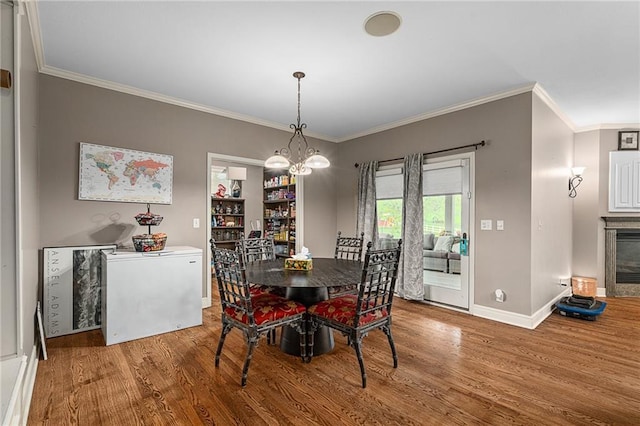 6715 NW 102nd Ter, Kansas City, MO 64154 - dining room featuring wood finished floors, baseboards, ornamental molding, and a chandelier