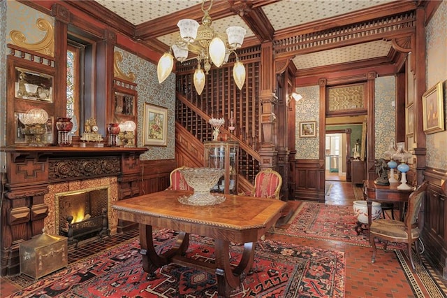 interior space with crown molding, wainscoting, a chandelier, beamed ceiling, and coffered ceiling