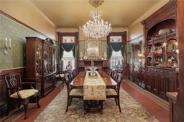 dining space featuring wallpapered walls, an inviting chandelier, and a wainscoted wall