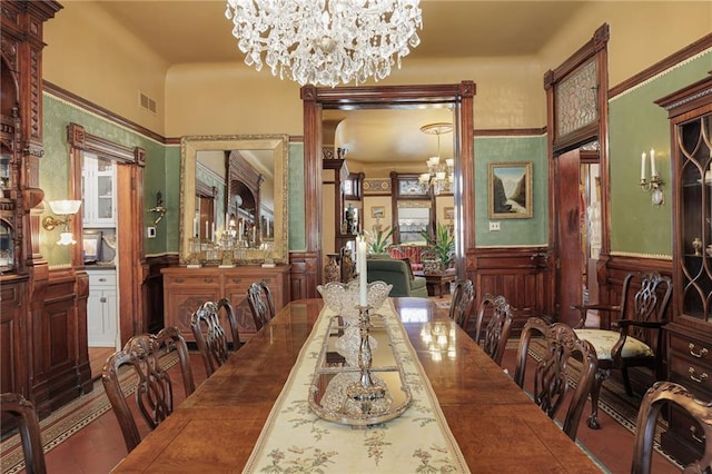 dining area with visible vents, wainscoting, and a chandelier