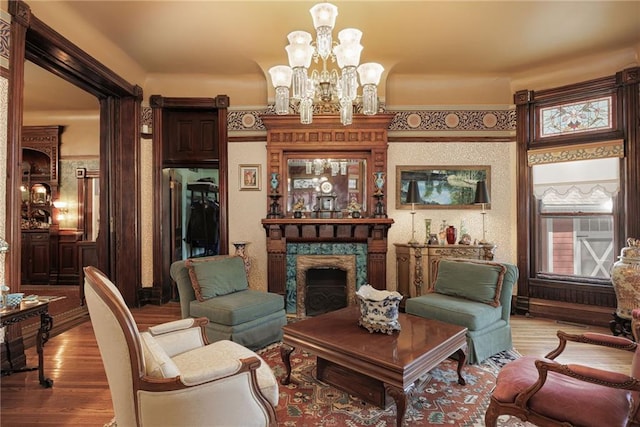 living area featuring light wood-style floors, a premium fireplace, and an inviting chandelier