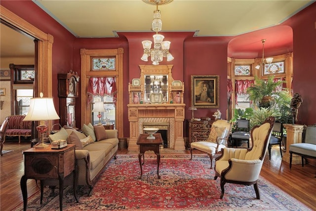 living area featuring a chandelier, wood finished floors, and a fireplace