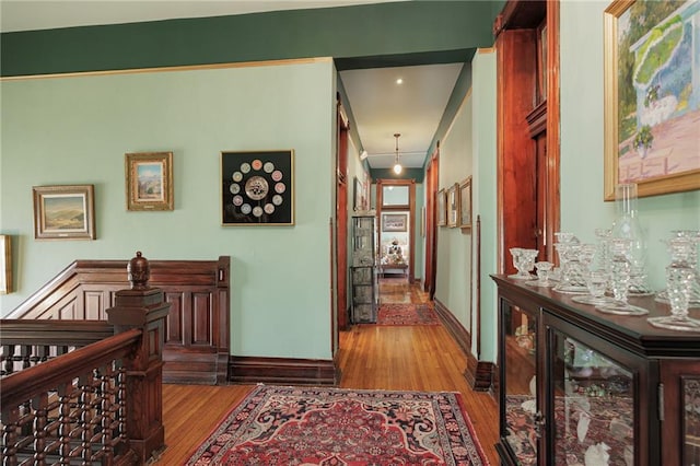 corridor with baseboards, beverage cooler, and wood finished floors