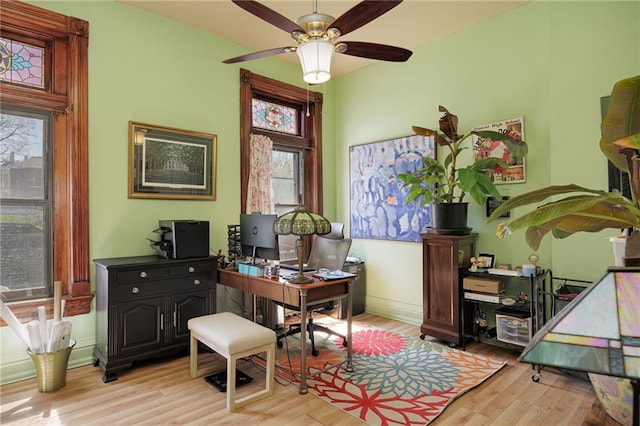 office space featuring baseboards, ceiling fan, and wood finished floors