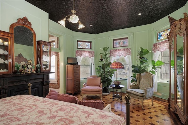 bedroom featuring an inviting chandelier and an ornate ceiling