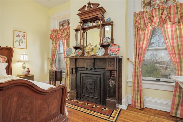 bedroom with wood finished floors and a fireplace