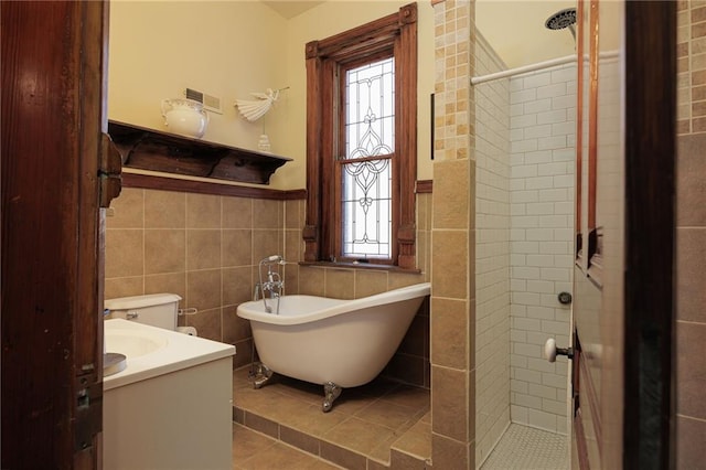 bathroom with tile patterned floors, a stall shower, tile walls, and a wealth of natural light