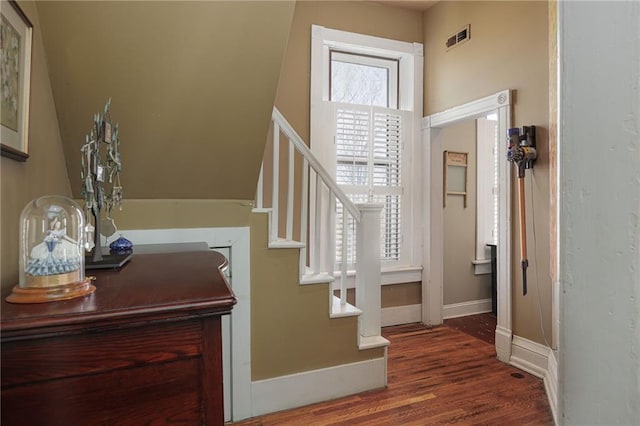 stairs with wood finished floors and visible vents