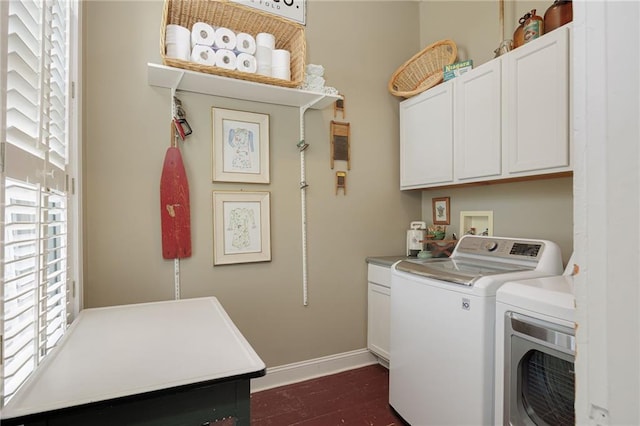 clothes washing area with baseboards, cabinet space, dark wood-type flooring, and washer and dryer
