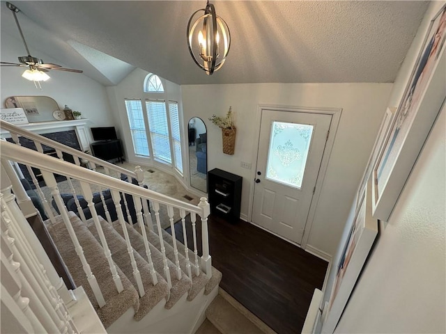 17525 W 111th Ct, Olathe, KS 66061 - foyer featuring dark wood finished floors, lofted ceiling, stairs, a chandelier, and a textured ceiling