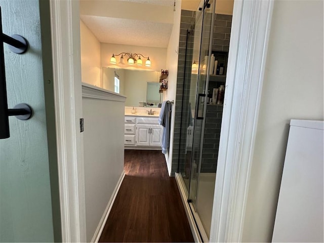 17525 W 111th Ct, Olathe, KS 66061 - bathroom featuring wood finished floors, a stall shower, vanity, and baseboards
