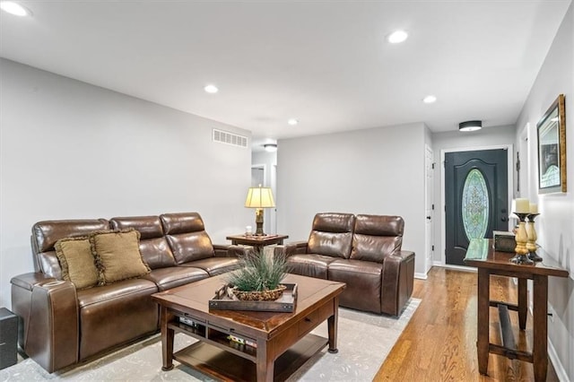 living room featuring light wood finished floors, recessed lighting, and visible vents
