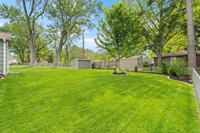view of yard with an outdoor structure, a fenced backyard, and a storage shed