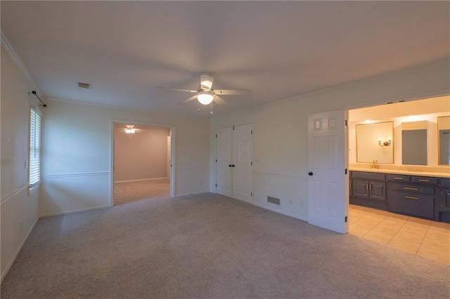 unfurnished bedroom with baseboards, visible vents, crown molding, and light colored carpet