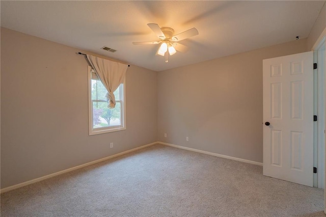 carpeted empty room with a ceiling fan, visible vents, and baseboards