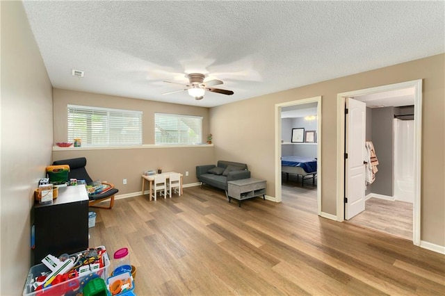 2136 Alder St, Leavenworth, KS 66048 - playroom featuring a ceiling fan, a textured ceiling, visible vents, baseboards, and light wood finished floors