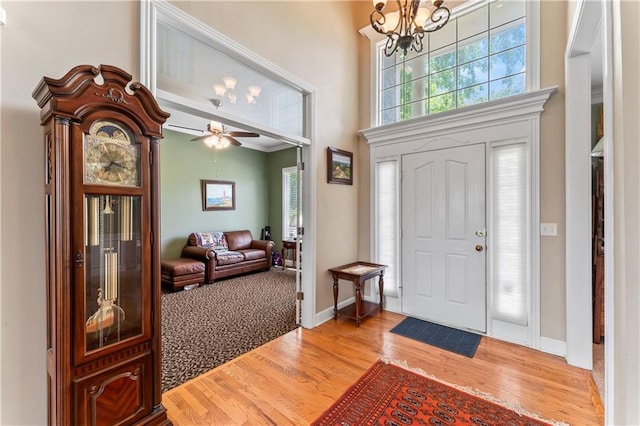 9800 W 147th St, Overland Park, KS 66221 - entryway featuring wood finished floors, a chandelier, a high ceiling, and ceiling fan