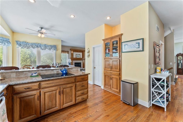 9800 W 147th St, Overland Park, KS 66221 - kitchen featuring black electric stovetop, light wood-style flooring, ceiling fan, brown cabinets, and recessed lighting