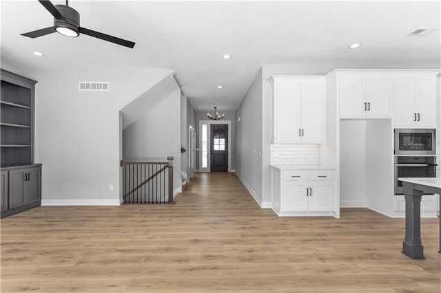 corridor featuring recessed lighting, a chandelier, light wood finished floors, baseboards, and visible vents