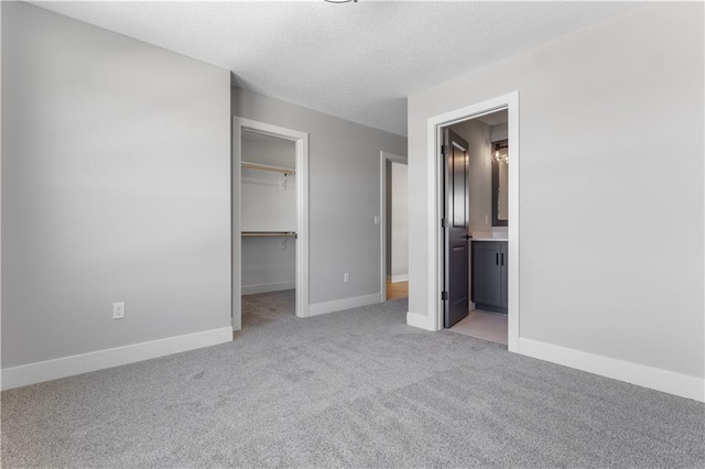 17148 S Heatherwood St, Olathe, KS 66062 - unfurnished bedroom featuring light carpet, a spacious closet, baseboards, a closet, and a textured ceiling