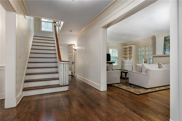 staircase featuring crown molding, wood finished floors, and baseboards