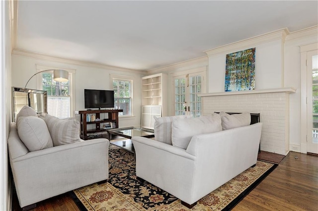 living area with crown molding, a wealth of natural light, wood finished floors, and a fireplace