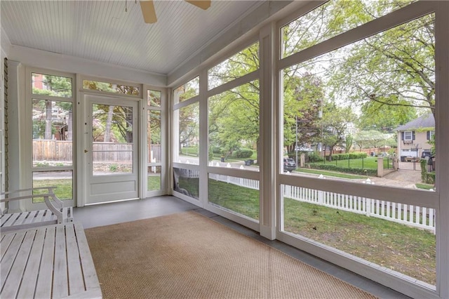 unfurnished sunroom featuring ceiling fan
