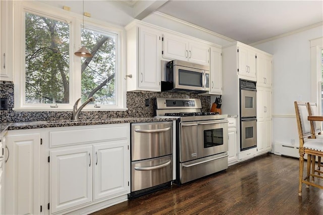 kitchen featuring dark stone counters, a sink, white cabinets, and appliances with stainless steel finishes