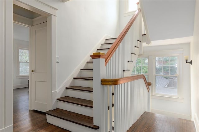 stairway with wood finished floors and baseboards