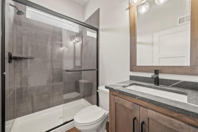 full bath with visible vents, vanity, toilet, and a shower stall
