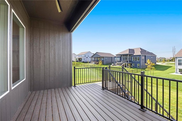 deck with a residential view and a yard